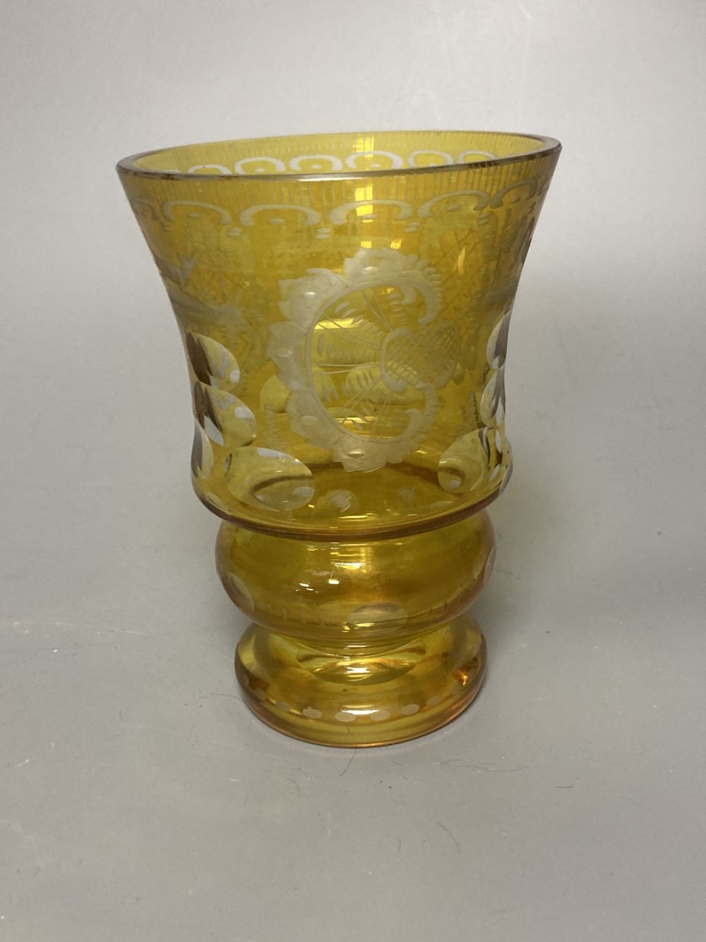A Bohemian amber flash cut beaker vase, a pair of amber wine glass coolers, 10cm high and a floral painted opaque glass beaker vase, in